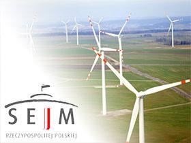 Logo Sejmu, w tle elektrownie wiatrowe