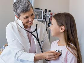 Lekarka osłuchuje dziewczynkę stetoskopem