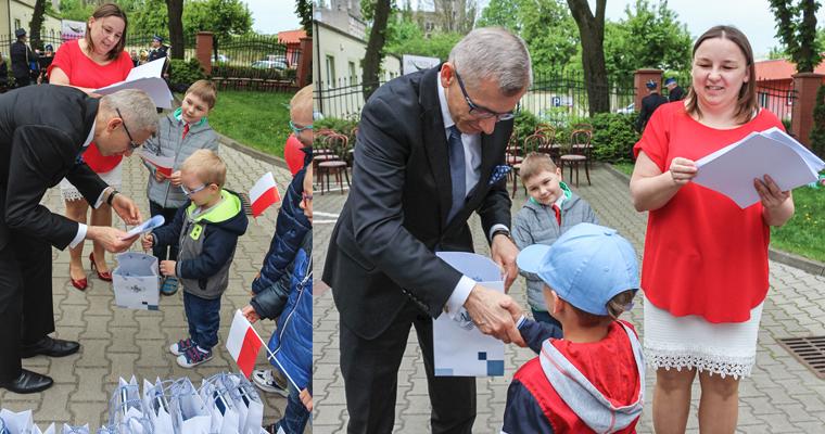Prezes NIK Krzysztof Kwiatkowski wręcza dzieciom dyplomy udziału w obchodach Dnia Flagi
