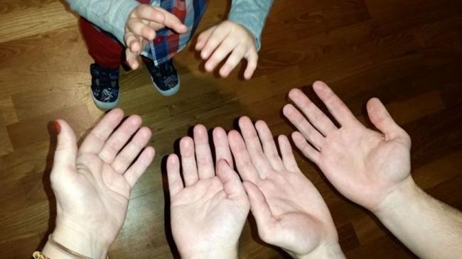 Dziecięce dłonie wyciągnięte w kierunku dorosłych dłoni
