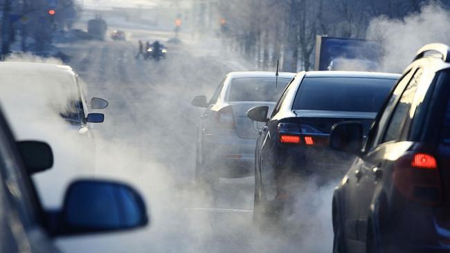 Samochody stojące w korku w chmurze spalin