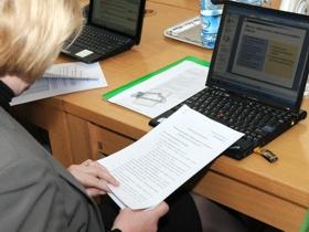 Osoba siedząca przed komputerem przeglądająca dokumenty