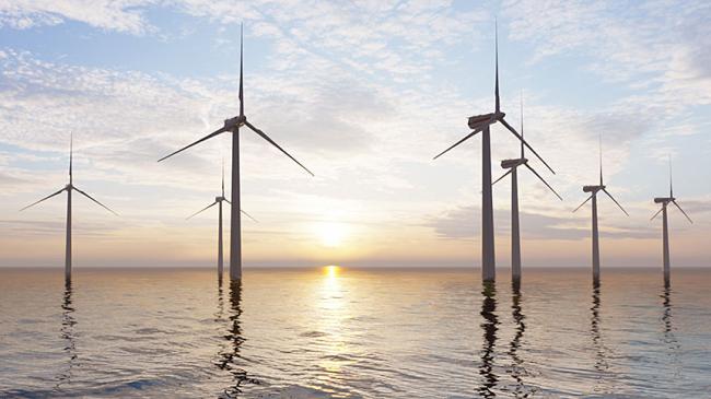 Turbiny wiatrowe morskiej elektrowni wiatrowej, w tle wschodzące słońce