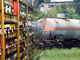 Półka z butelkami alkoholu obok cysterna kolejowa