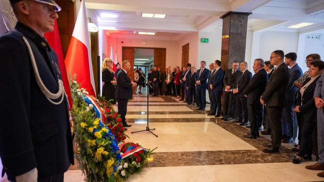 Uroczystości rocznicowe w siedzibie NIK, pracownicy zgromadzeni przed tablicami pamiątkowymi w holu głównym