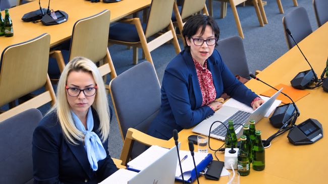 Doradczyni ekonomiczna: Sylwia Zakrzewska oraz Dyrektor Karolina Wirszyc-Sitkowska siedzące na sali podczas posiedzenia Komisji Infrastruktury