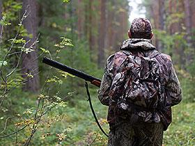 Myśliwy z bronią wchodzi do lasu
