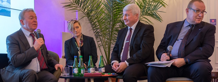 Członek ETO Janusz Wojciechowski zabiera głos, obok pozostali uczestnicy debaty.