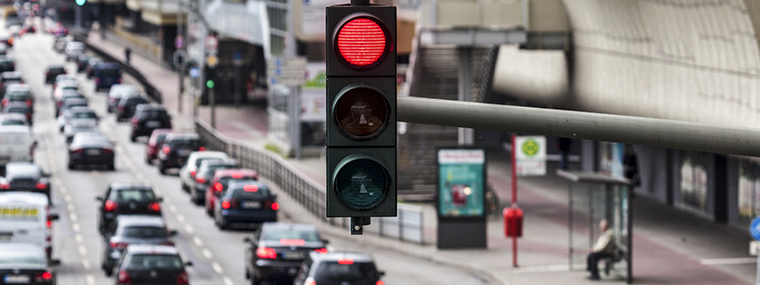 Sygnalizator z czerwonym światłem nad korkiem ulicznym