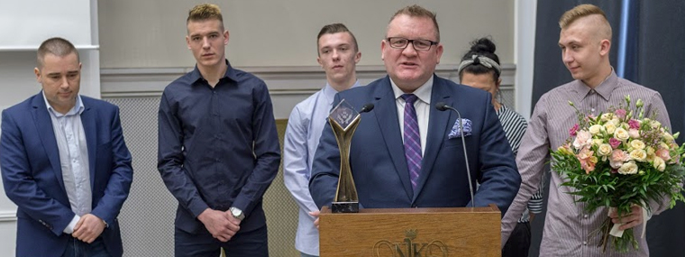 Krzysztof Mikos dyrektor Zakładu Poprawczego w Ostrowcu Świętokrzyskim w tle jego wychowankowie i współpracownicy