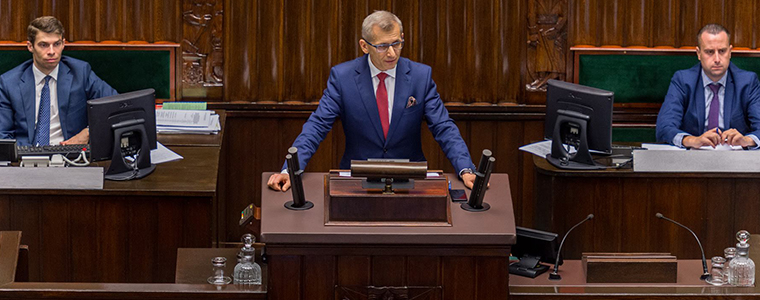 Prezes NIK Krzysztof Kwiatkowski przedstawia analizę budżetu państwa w Sejmie RP z tyłu pracownicy Sejmu