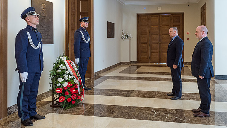 Prezes NIK Marian Banaś i Dyrektor Generalny NIK Andrzej Styczeń oddają hołd przed pamiątkową tablicą Prezydenta RP Lecha Kaczyńskiego