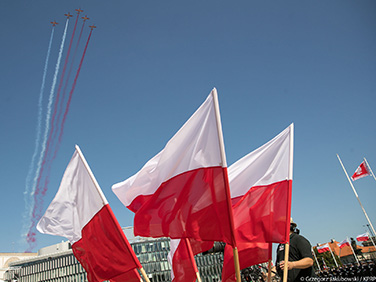 Samoloty (wypuszczające dym układający się&nbsp;w flagę Polski) przelatujące nad zgromadzonymi na&nbsp;obchodach 100. rocznicy Bitwy Warszawskiej fot. Grzegorz Jakubowski/KPRM