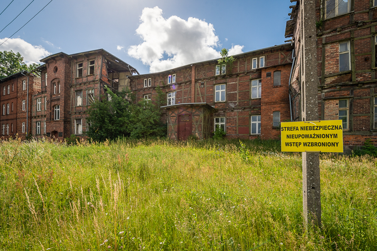 A view on the former KL Soldau building in Działdowo, in the foreground a signboard saying: DANGER! KEEP OUT!