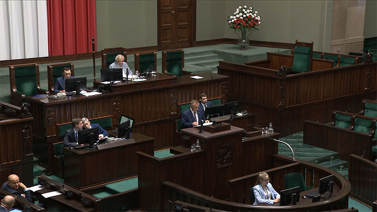 Widok na mównicę i prezydium Sejmu, na mównicy Prezes NIK Marian Banaś. Obradom przewodniczy Wicemarszałek Ryszard Terlecki