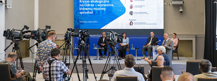 Prezes NIK Marian Banaś wita uczestników debaty - widok na panelistów i zgromadzonych gości i dziennikarzy