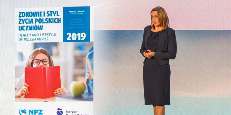 dr hab. n. med. Małgorzata Wójcik, obok okładka raportu z badań Zdrowie i styl życia polskich uczniów